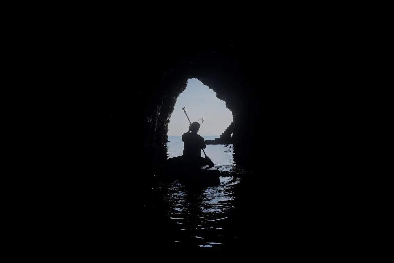 A paddler at the cave mouth, seen from inside
